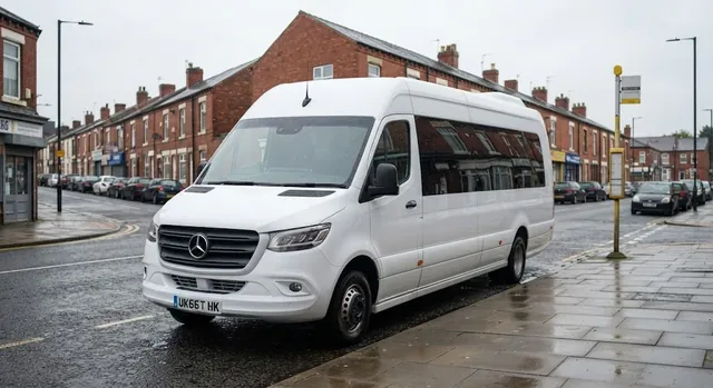 White 16 seater Mercedes-Benz Sprinter minibus parked beside a red-brick terrace