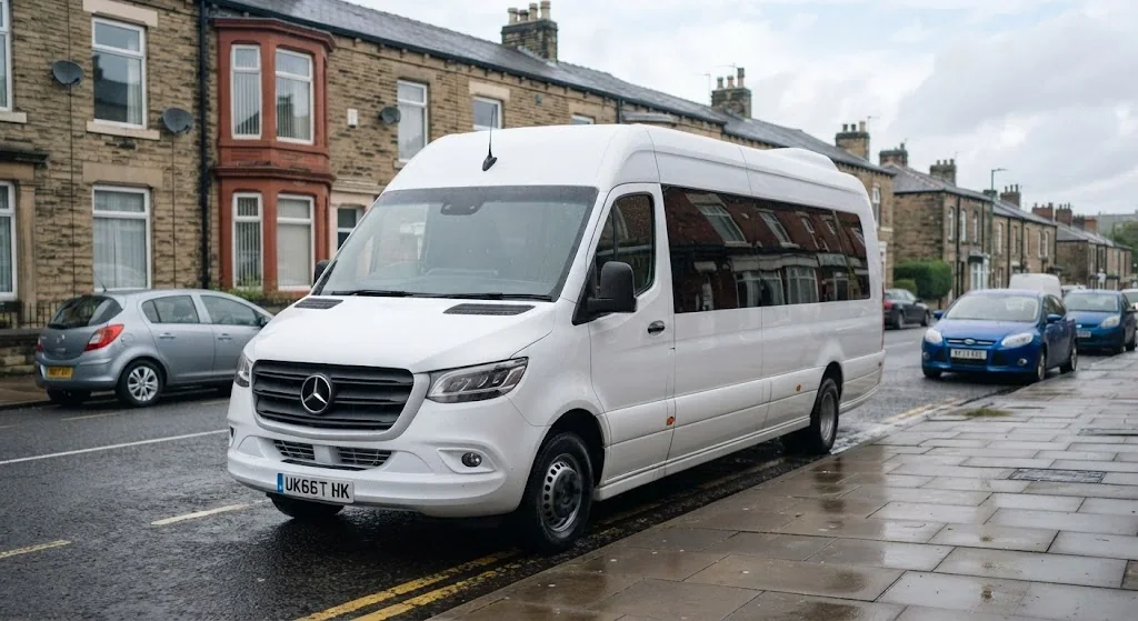 White 16 seater Mercedes-Benz Sprinter minibus parked on a stone-built terraced street